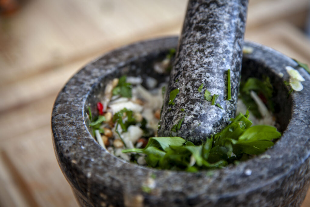 Die frischen Pesto Zutaten werden im Mörser zermahlen