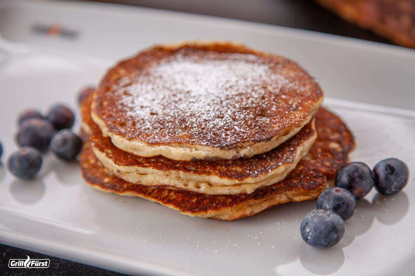 Milchreis-Pancakes dekoriert mit Puderzucker und Blaubeeren