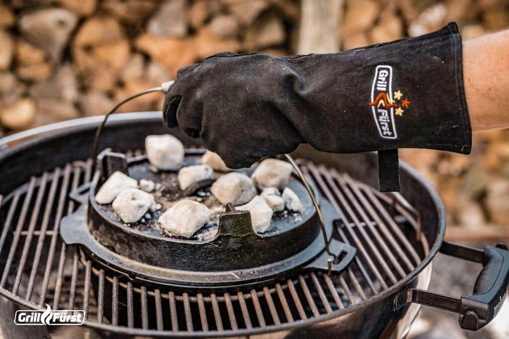 Grillhandschuhe aus Leder beim Anheben eines Dutch Oven