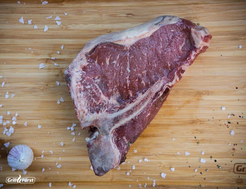 Kerntemperatur T-Bone Steak: Rohes T Bone auf einem Holzbrett