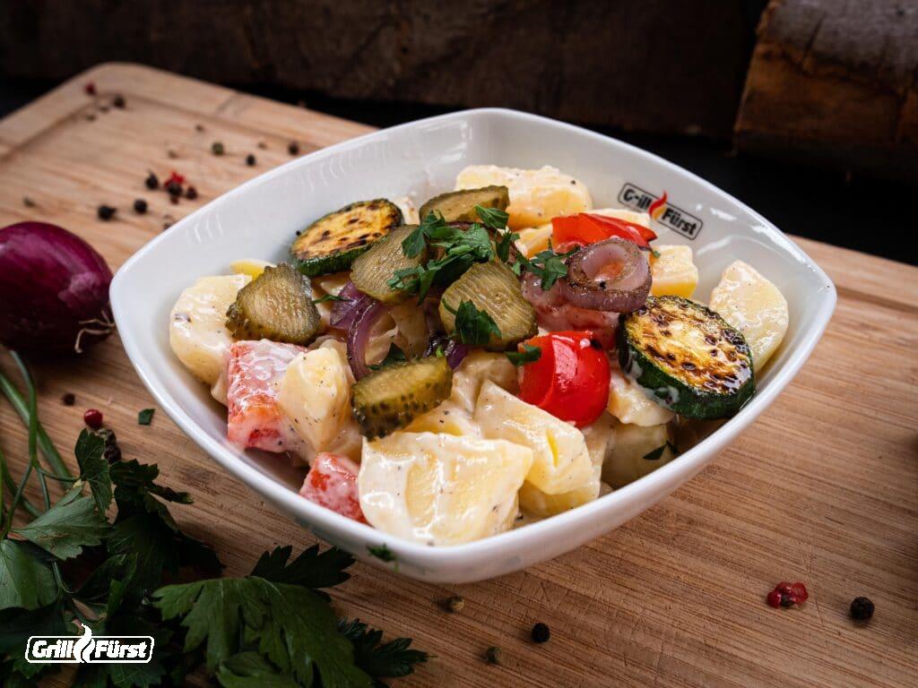 Gegrillter Kartoffelsalat mit viel Gemüse in Schuessel