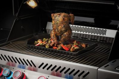 Napoleon Keramik Grillplatte mit Geflügelaufsatz, hier mit knusprigem Grillhähnchen und Gemüse im Gasgrill. Napoleon Keramik Grillplatte mit Geflügelaufsatz, hier mit knusprigem Grillhähnchen und Gemüse im Gasgrill.