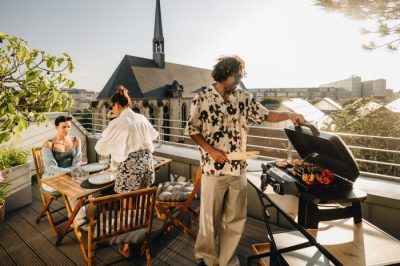 Enders eUrban 2 Elektro-Tischgrill mit geöffnetem Deckel beim Grillen von Fleisch und Gemüse auf der Terrasse. Enders eUrban 2 Elektro-Tischgrill mit geöffnetem Deckel beim Grillen von Fleisch und Gemüse auf der Terrasse.
