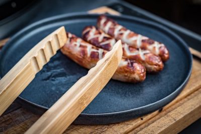 Grillfürst Bambus-Grillzange mit Würstchen auf der Grillplatte Grillfürst Bambus-Grillzange mit Würstchen auf der Grillplatte