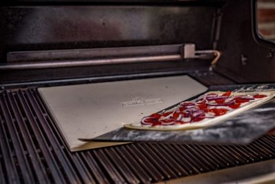 Grillfürst Pizzastein eckig aus Cordierit Die Pizza mit einem Blech auf den vorgeheizten Stein schieben.