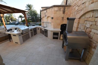 Die Outdoor Küche mit Einbaugrill, Spüle, Seitenbrenner, Kühlschrank, Schubladen, Türen und Pizzaofen