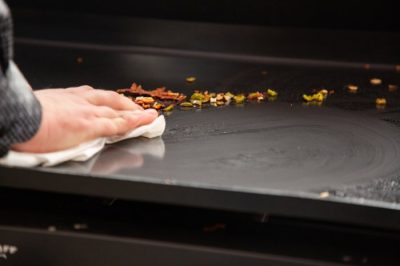 Die Plancha wird mit einem feuchten Tuch gereinigt, nachdem Rest mit einem Schaber gelöst wurden Die Plancha wird mit einem feuchten Tuch gereinigt, nachdem Rest mit einem Schaber gelöst wurden