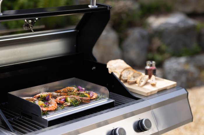 Grillfürst Edelstahl Plancha auf dem Grillrost mit Scampi, Rosmarin und Zitrone