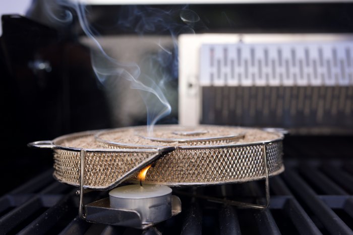 Grillfürst Kaltrauchgenerator auf einem Gasgrill mit angezündetem Teelicht