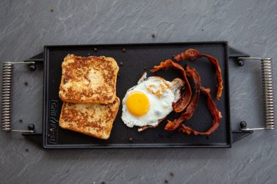 Grillfürst eckige Gusseisen-Grillplatte mit zwei Griffen, belegt mit geröstetem Toast, Spiegelei und knusprigem Bacon. Grillfürst eckige Gusseisen-Grillplatte mit zwei Griffen, belegt mit geröstetem Toast, Spiegelei und knusprigem Bacon.