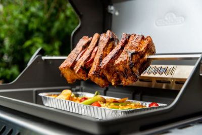Drehspieß mit gegrilltem Fleisch und Gemüse im Gasgrill Drehspieß mit gegrilltem Fleisch und Gemüse im Gasgrill